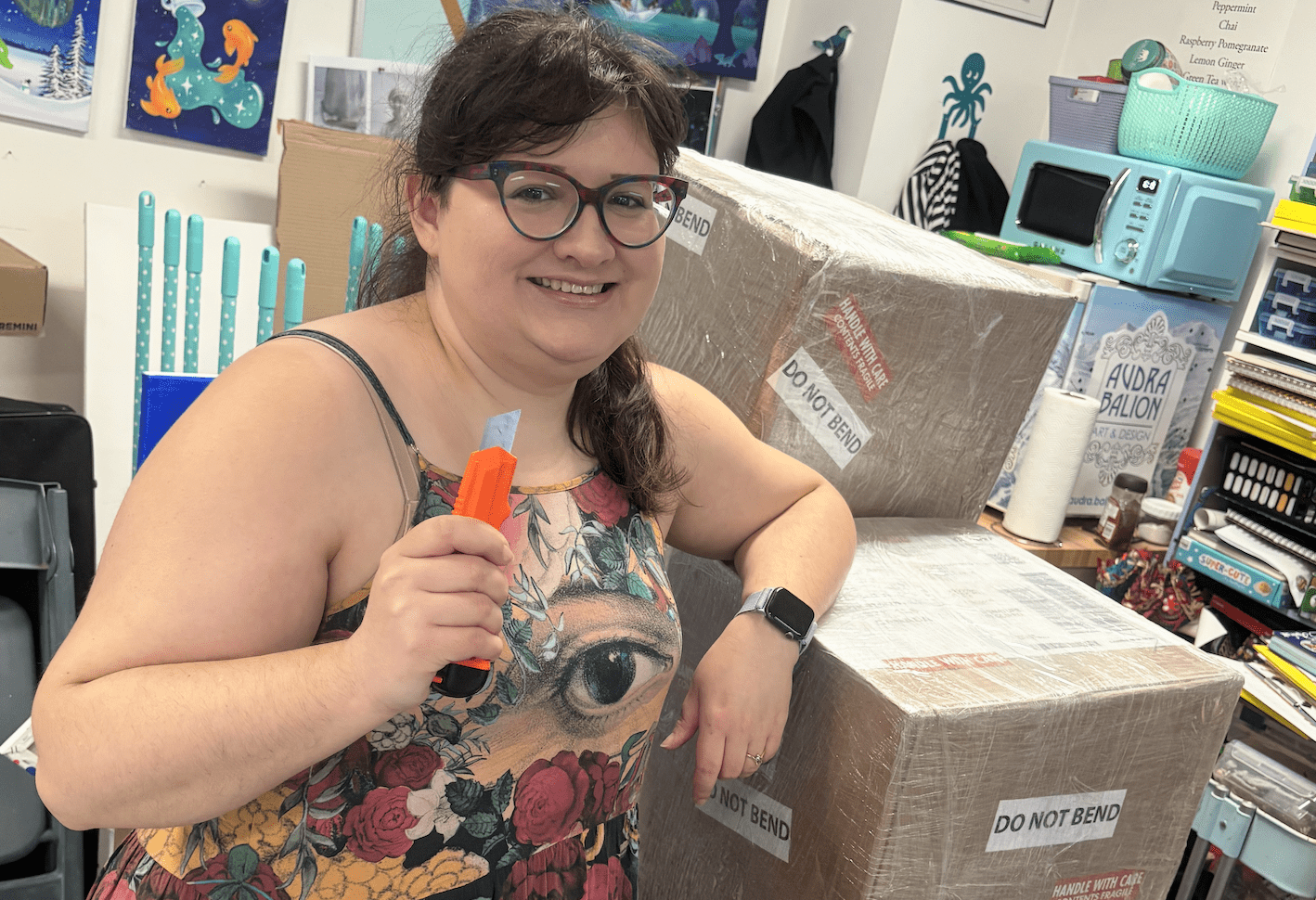 Audra Balion smiles, ready to open up a stack of boxes.